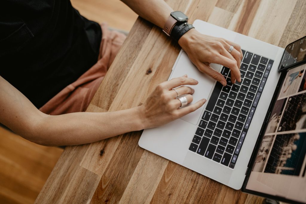 Person writing first-hand content on a laptop to show E-E-A-T experience