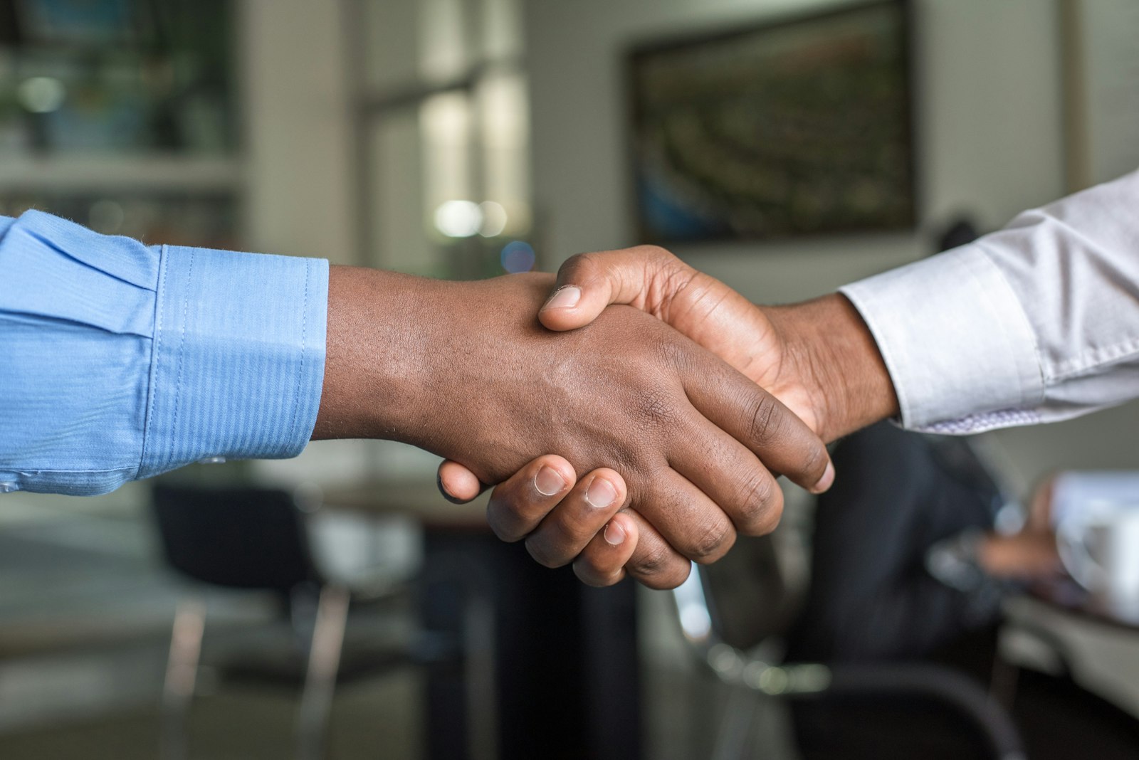 Two people shaking hands, showing how business partnerships support link building