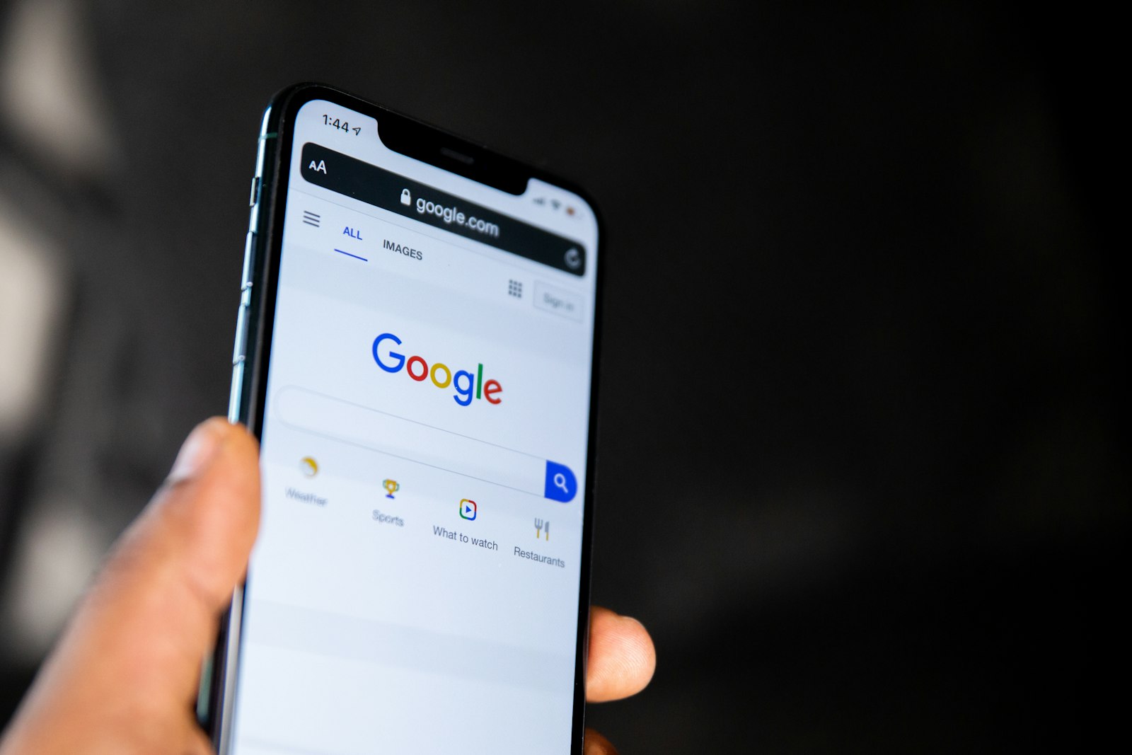 Hand holding a smartphone showing Google search, illustrating SEO vs SEM for Malaysian businesses
